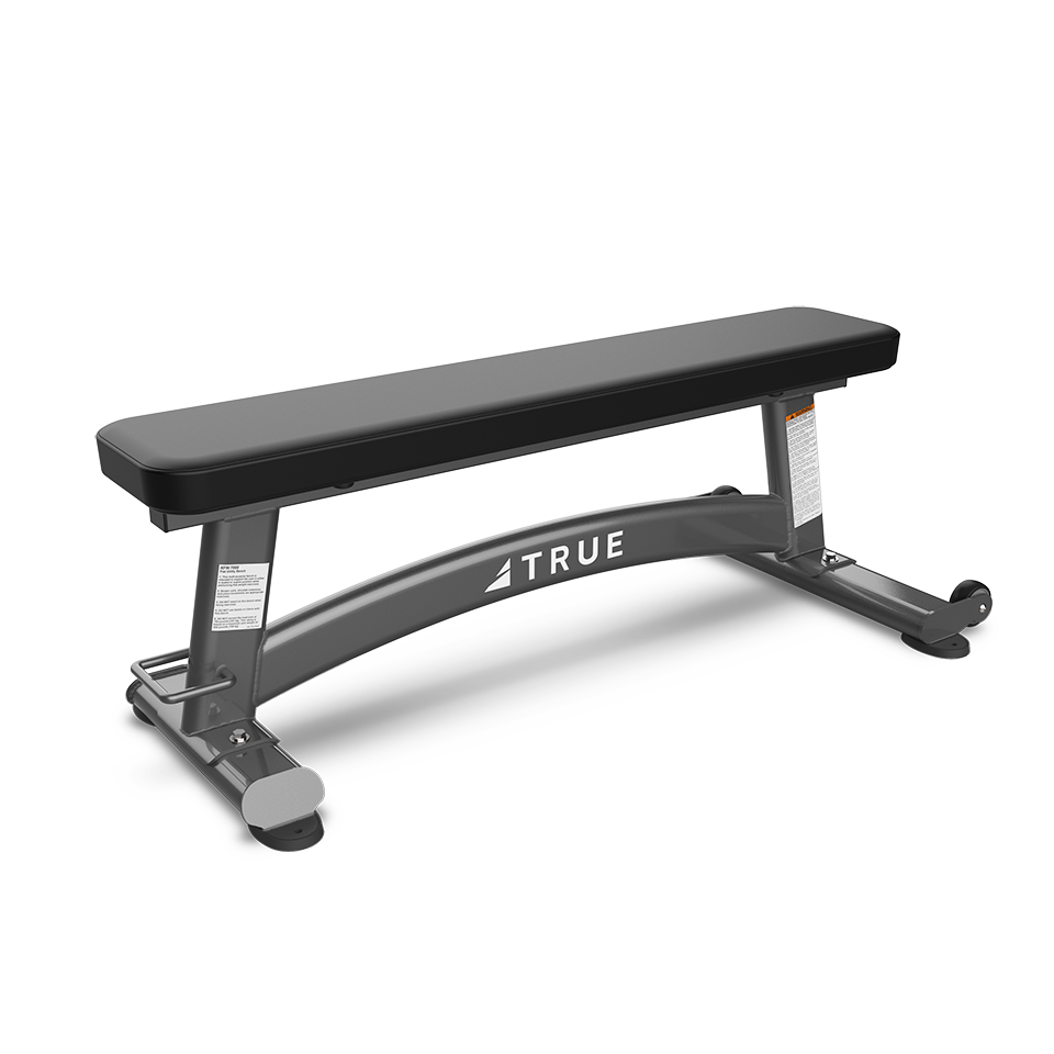 A flat workout bench with a black padded top and a sturdy gray metal frame, labeled TRUE on the side, designed for use in fitness and weightlifting exercises.