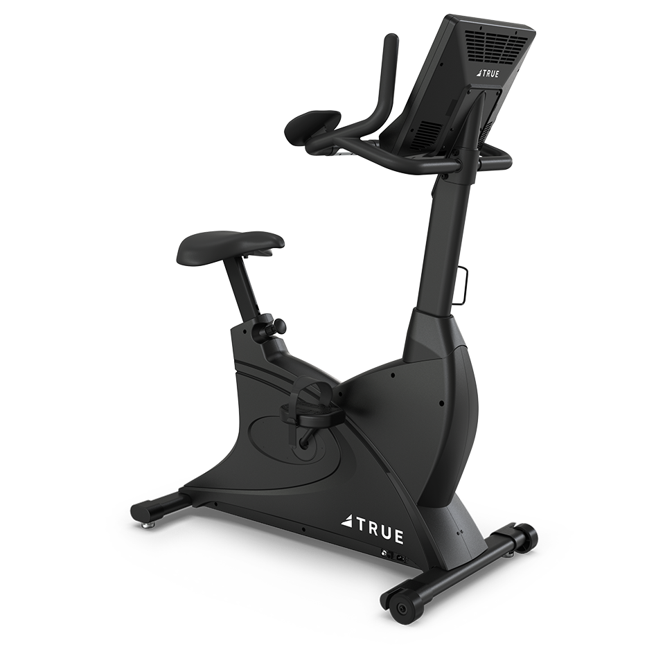 A black stationary exercise bike with an adjustable seat, handlebars, pedals, and a digital display screen on the front. The brand TRUE is visible on the side of the machine.