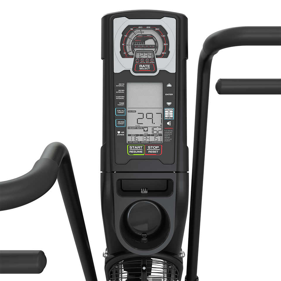 Close-up of a digital display panel on a black exercise bike, showing workout data including time, distance, and calories. Handlebars are partially visible on both sides. The background is plain white.