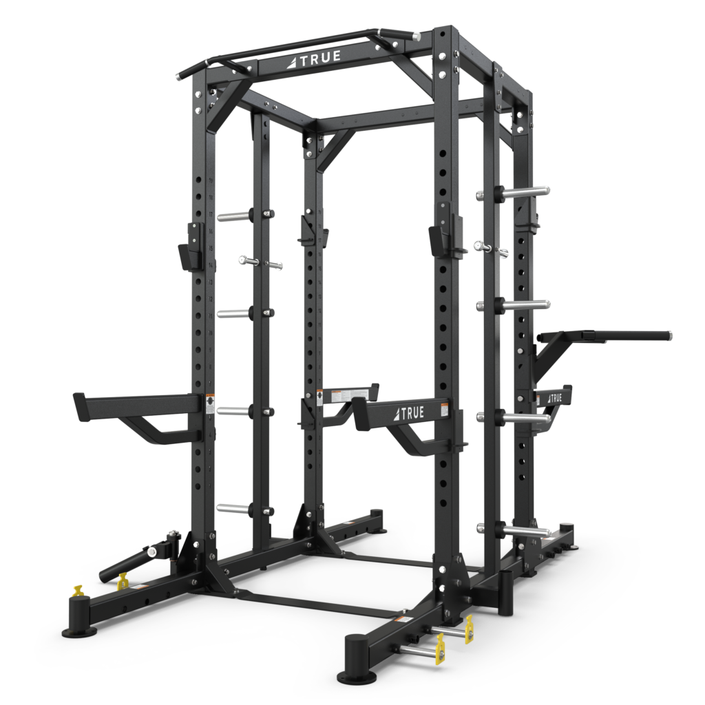 A black metal power rack with adjustable bars, pull-up handles, dip bars, plate storage, and safety catches, designed for weightlifting and strength training, sits on a white background.