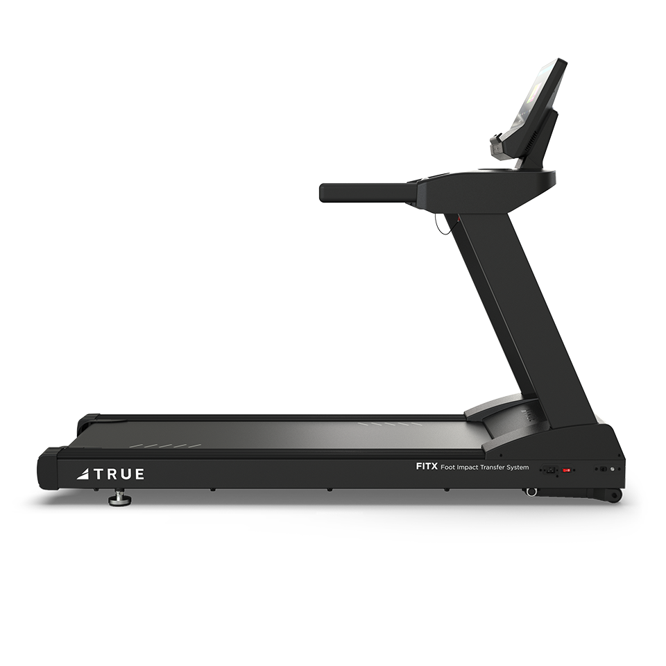 A black TRUE treadmill with a digital display screen, side rails, and a foot impact transfer system, photographed from the side against a plain white background.