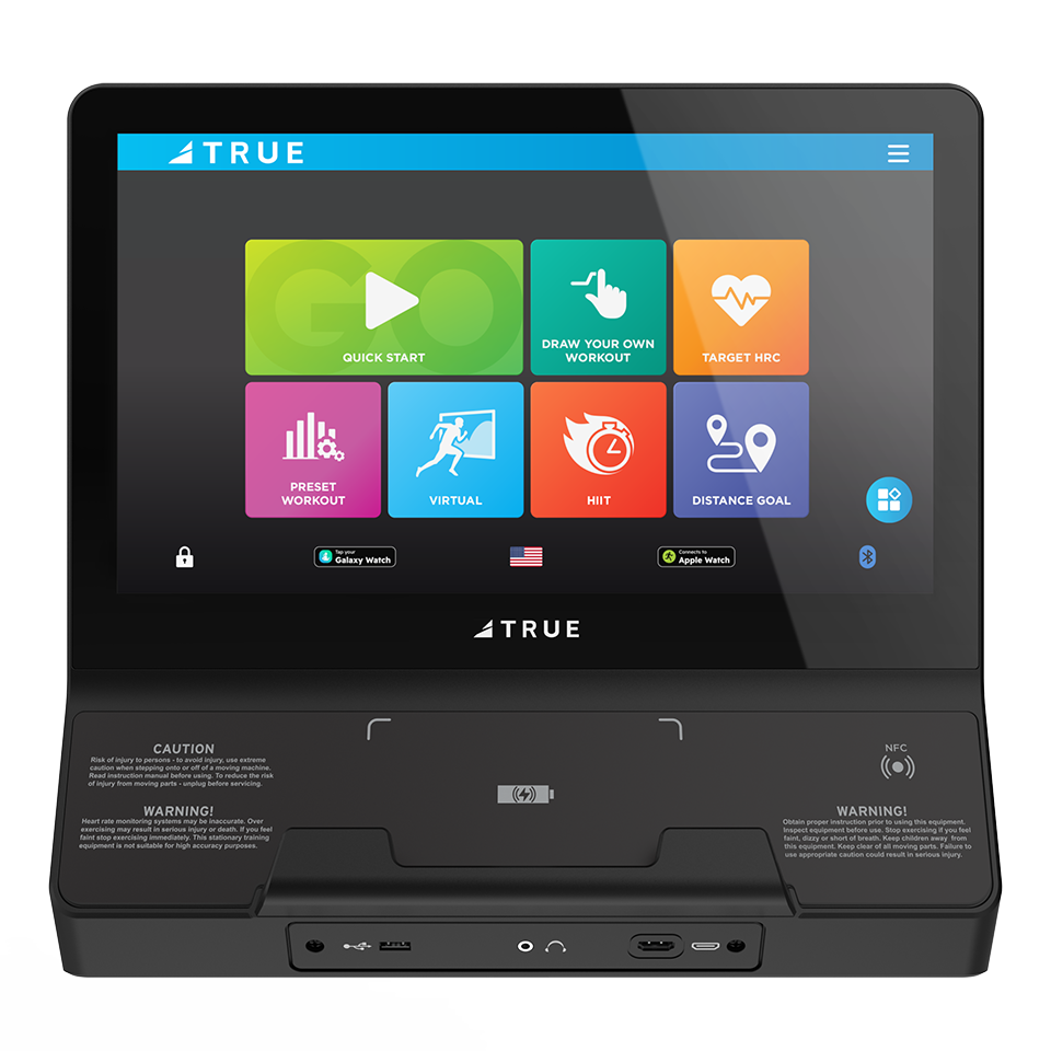 A touchscreen fitness machine console displays colorful workout options, including Quick Start, Custom Workout, Target HRC, Preset Workout, Virtual, HIIT, Distance Goal, and a settings icon.