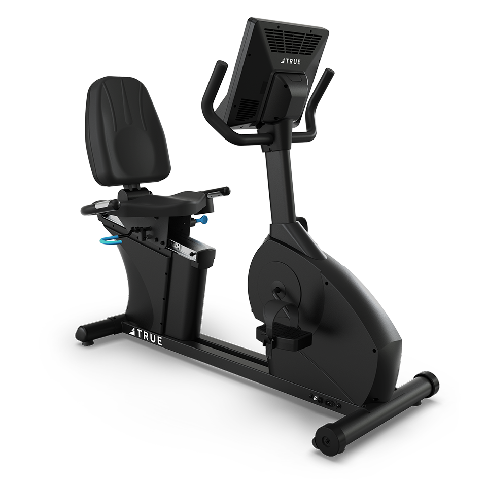 A black recumbent exercise bike with a padded seat, adjustable backrest, pedals, and a digital display screen. The bike has handles on either side of the screen and is labeled TRUE on the frame.