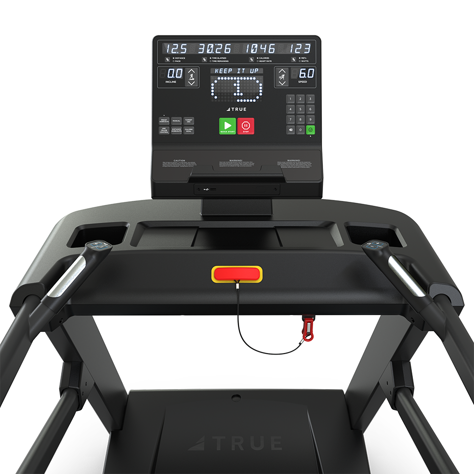 Close-up of a treadmill control panel displaying workout stats like time, distance, speed, and heart rate, with buttons for start, stop, and adjustments. A safety key with a red cord is attached to the console.