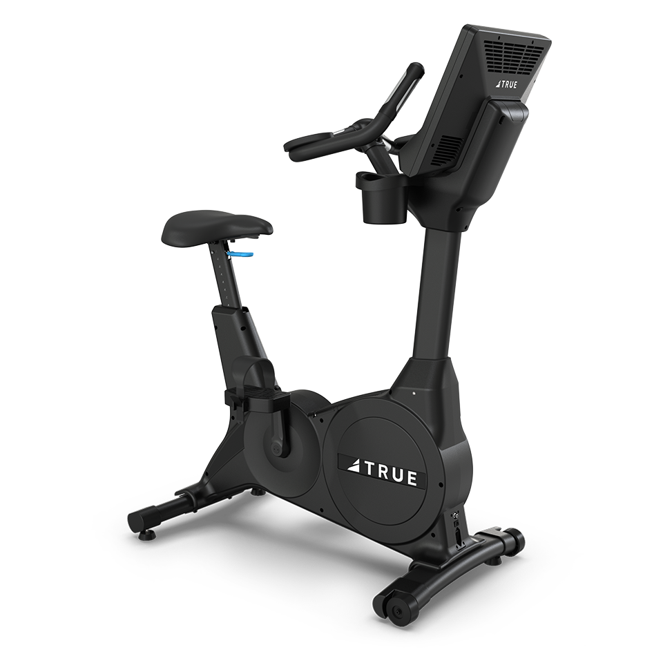 A black stationary exercise bike with a padded seat, digital display, handlebars, and the brand name TRUE on the body, positioned on a white background.