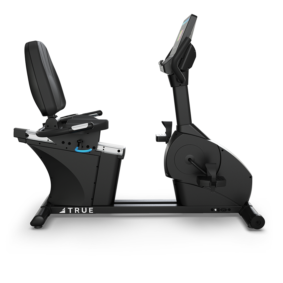 A black recumbent exercise bike with a padded seat, backrest, pedals, and digital display screen, shown from the side on a white background. The brand name TRUE is visible on the frame.